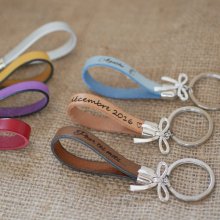 Nøkkelring i skinn som kan personaliseres med gravering dekorert med en sløyfe.