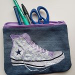 Flatt etui med broderte lilla joggesko